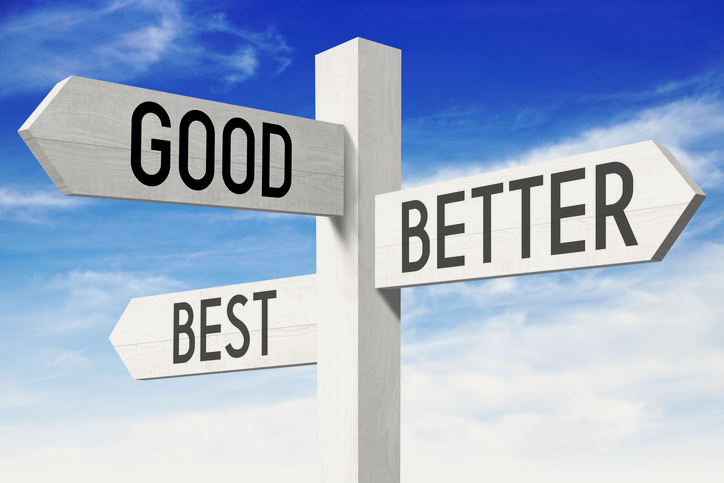 White wooden signpost/ crossroads sign with three arrows - "good", "better", "best".